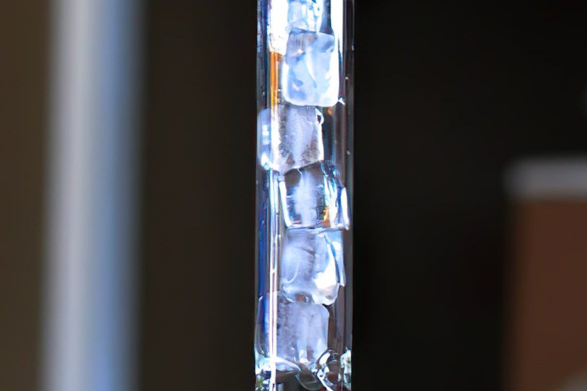 Detalhe do ice bong de vidro repleto de pedras de gelo em sua coluna